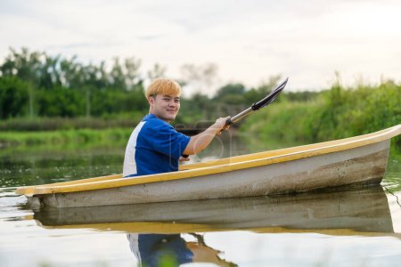 Photo for Smiling man tourists rowing boat  on the river.ravel, vacation holiday and outdoor activity. - Royalty Free Image
