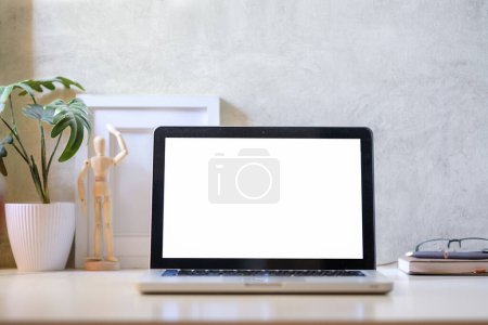 Photo for Laptop computer, coffee cup, potted plant and picture frame on creative workplace. Blank screen for your advertising text. - Royalty Free Image