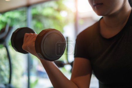 Photo for Strong young sporty woman lifting dumbbells at gym. Healthy lifestlye. Sport background. - Royalty Free Image