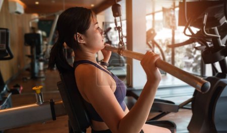 Photo for Strong young woman doing exercise for back with lat pulldown machine in gym. Fitness, workout, gym exercise and healthy lifestyle concept. - Royalty Free Image
