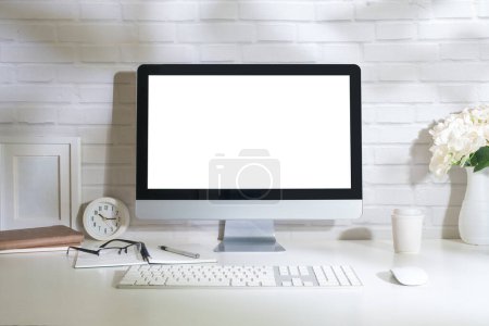 Foto de Interior de la oficina con monitor de computadora en blanco y suministros de oficina en mesa blanca. - Imagen libre de derechos