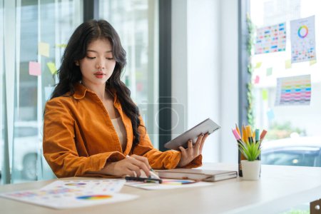 Foto de Mujer creativa joven que utiliza la tableta gráfica y un lápiz lápiz óptico en el lugar de trabajo moderno. - Imagen libre de derechos
