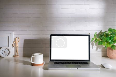 Photo for Laptop computer, coffee cup, potted plant and picture frame on creative workplace. Blank screen for your advertising text. - Royalty Free Image