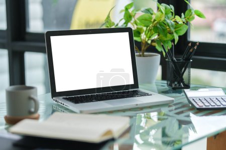 Photo for Laptop computer with white empty display, calculator and coffee cup on office desk. - Royalty Free Image