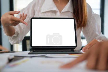 Foto de Mujer de negocios irreconocible mostrando tableta digital con pantalla en blanco en la mesa de reuniones. - Imagen libre de derechos