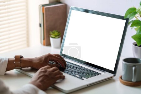 Foto de Vista lateral del hombre joven usando el ordenador portátil mientras está sentado en un lugar de trabajo cómodo. - Imagen libre de derechos