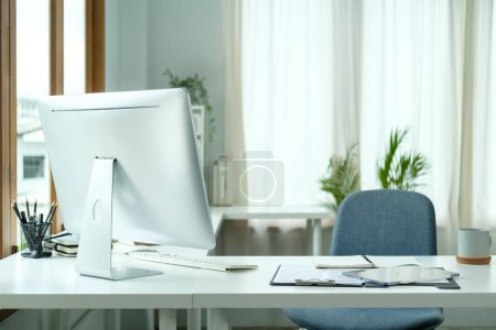 Photo for Comfortable workplace with computer monitor, office supplies and document on white table. - Royalty Free Image