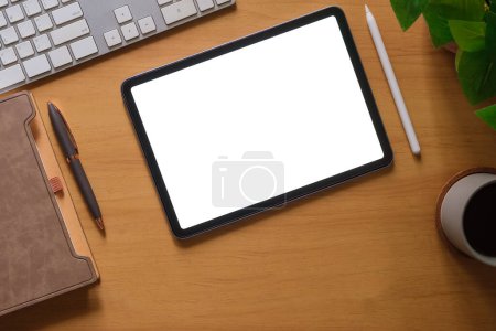 Foto de Plancha plana, vista superior de la tableta digital con pantalla en blanco, ordenador portátil, portátil y taza de café en la mesa de madera. - Imagen libre de derechos