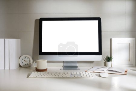 Foto de Espacio de trabajo mínimo con computadora de pantalla blanca y suministros de oficina en mesa blanca. - Imagen libre de derechos