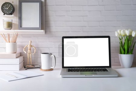 Foto de Escritorio de oficina con computadora portátil, taza de café, libros y macetas. - Imagen libre de derechos