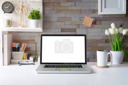 Photo for Laptop computer, picture frame, houseplant and stationery on white table. Modern workplace. - Royalty Free Image