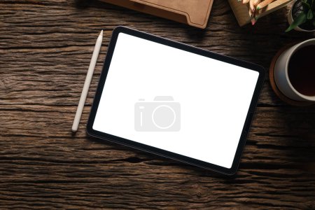 Téléchargez les photos : Tablette numérique avec écran blanc, ordinateur portable, tasse à café et livre sur table en bois. - en image libre de droit