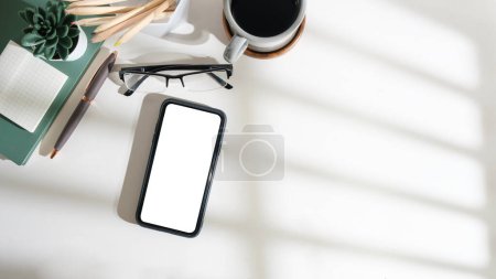 Foto de Teléfono inteligente de vista superior con pantalla vacía, portátil y taza de café en el escritorio de oficina de madera. Copia espacio para tu texto. - Imagen libre de derechos