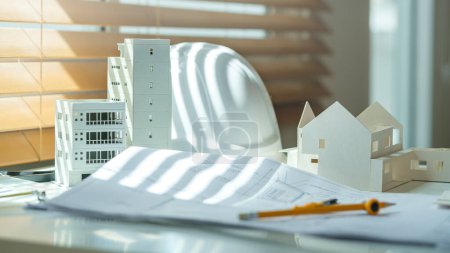 Photo for Architectural model, hardhat on desk with drawing technical tools and blueprints. Real estate business, building and construction. - Royalty Free Image