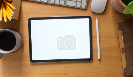 Photo for Flat lay, top view of digital tablet with white screen, coffee cup, glasses and notepad on wooden working desk. - Royalty Free Image