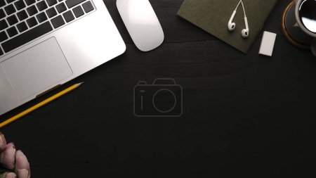 Foto de Vista superior de la computadora portátil, taza de café, ratón y auriculares en la mesa negra. Copia espacio para tu texto. - Imagen libre de derechos
