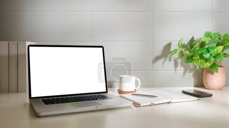 Foto de Mock up laptop, coffee cup, houseplant and supplies on white table. Blank screen for your advertise text. - Imagen libre de derechos