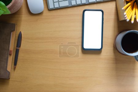 Foto de Smartphone de vista superior con pantalla en blanco, portátil y taza de café en mesa de madera. - Imagen libre de derechos