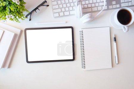 Foto de Plancha plana, vista superior de la tableta digital con pantalla en blanco, ordenador portátil, portátil y taza de café en la mesa. - Imagen libre de derechos