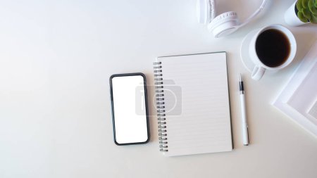 Photo for Top view smart phone with empty screen, notebook and coffee cup on office desk. Copy space for your text. - Royalty Free Image