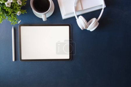 Foto de Escritorio de oficina con vista superior con tableta digital, taza de café y portátil. - Imagen libre de derechos