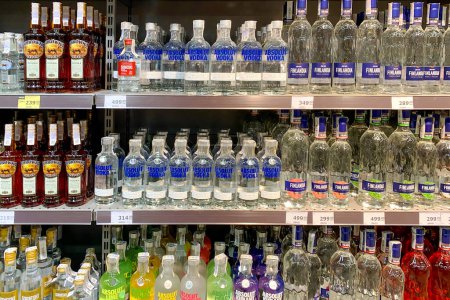 Téléchargez les photos : Kiev, Ukraine, juin 2023 : - Rangées différentes bouteilles de vodka en verre empilées sur des étagères dans un supermarché à vendre. Boissons alcoolisées fortes dans l'étagère. Concentration sélective. Gros plan. - en image libre de droit