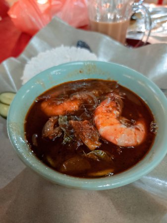 Téléchargez les photos : Un bol de crevettes chili ou sambal udang sur foyer sélectif et fond flou. - en image libre de droit