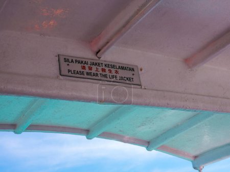 Photo for Please wear the life jacket sign on the boat in English, Malay and Chinese languages. - Royalty Free Image