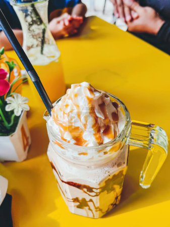 Photo for Frappuccino in large glass mug on the table at cafe in a sunny day. - Royalty Free Image