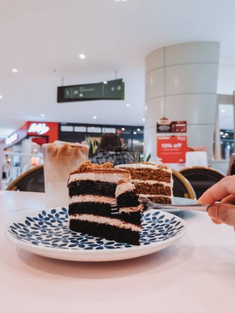 Téléchargez les photos : Putrajaya, Malaisie - 8 juin 2022 Gâteaux de velours rouge et de carotte sur la table avec latte glacé pour l'heure du thé dans le centre commercial IOI City. - en image libre de droit