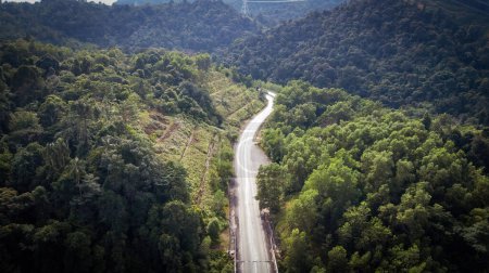 Téléchargez les photos : An aerial view of the road across the rainforest mountains in Hulu Selangor, Malaysia. - en image libre de droit