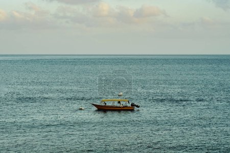 Un bateau vide flottant au lever du soleil dans l'île Perhentienne, Terengganu, Malaisie.