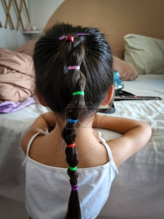 Photo for Young girl with colourful braided hair from behind. - Royalty Free Image