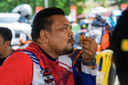 Foto de Pahang, Malasia - 24 de septiembre de 2022 Hombre malayo comiendo en la cafetería local con amigos. - Imagen libre de derechos