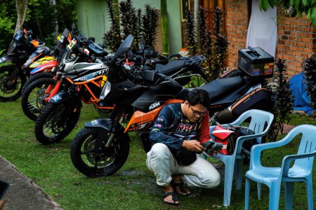 Photo for Pahang, Malaysia - Sept 24, 2022 Enduro motorcycles at the parking lot with a man sitting next to them. - Royalty Free Image