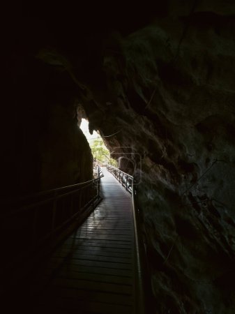Glühender Ausstieg aus der Höhle mit Wanderweg in der Kelam Höhle, Perlis, Malaysia.