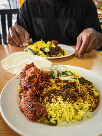 Kandar-Reis, berühmtes indisch-malaiisches Fusionsessen, serviert mit frittiertem Hähnchen, Gemüse und Papadom.