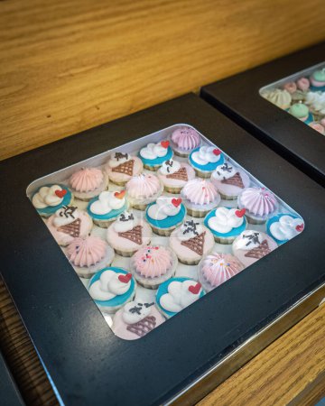 Téléchargez les photos : Une boîte de cupcakes au design coloré. - en image libre de droit