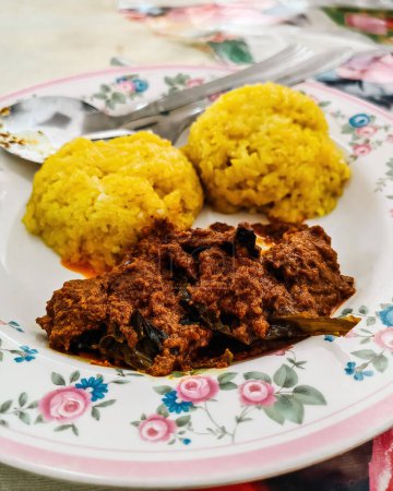 Dekorative traditionelle Gerichte Malaysias und Indonesiens, Rindfleisch "Rendang" mit gelbem klebrigen Reis, auch bekannt als "Pulut Kuning"".