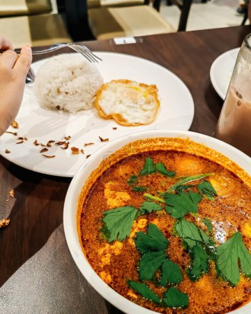 Tom Yam Kung, Garnelen-Zitronen-Suppe mit Pilzen, thailändisches Essen in weißer Schüssel serviert mit Reis und Ei.