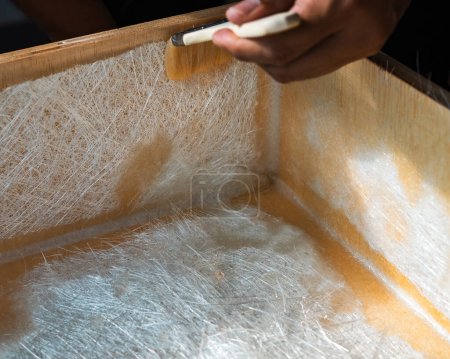 Brushing solution through fiberglass sheets on a wooden box. A diy project at home.