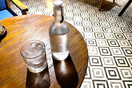 Téléchargez les photos : Vodka fraîche rafraîchissante dans la bouteille avec des roches de glace dans le verre servi dans le pub bonne liqueur dans les happy hours - en image libre de droit