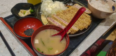 Foto de Indonesia comida fusión japonesa, comida japonesa cocinero en estilo indonesio, gyukatsu, karage de carne de res, ensalada, y sopa de tofu en el restaurante indonesio local - Imagen libre de derechos