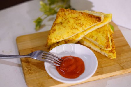 Fresh fried delicious french toast sandwich with cheese filling plated in white plate, just freshly fried in the restaurant