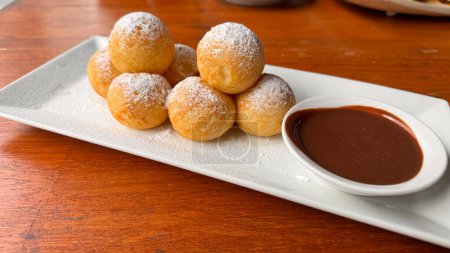 Photo for Poffertjes Dutch Mini Pancakes with chocolate sauce white plate - Royalty Free Image