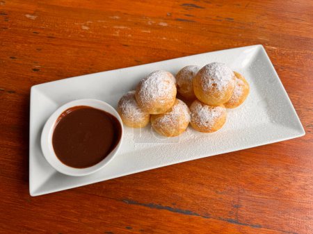 Photo for Poffertjes Dutch Mini Pancakes with chocolate sauce white plate - Royalty Free Image