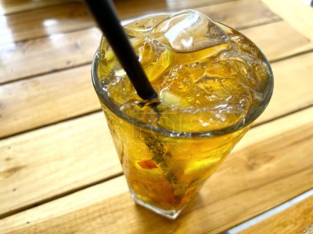 Téléchargez les photos : Cocktail de fruits frais boisson alcoolisée avec rhum et whisky dans un verre clair et morceau de glace sur un fond de table en bois - en image libre de droit