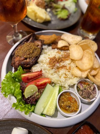 Nasi uduk ayam bakar, oder Kokosmilch-Aroma-Reis, serviert mit gegrilltem Huhn, frischem Salat und Chili-Paste traditionelles indonesisches Essen, indonesisches Streetfood, hausgemachtes Essen