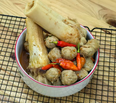 Delicious Indonesian meatballs with huge bones contains bone marrow in spicy beef broth and chilies served in a bowl