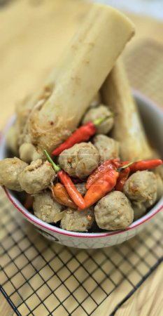 Delicious Indonesian meatballs with huge bones contains bone marrow in spicy beef broth and chilies served in a bowl